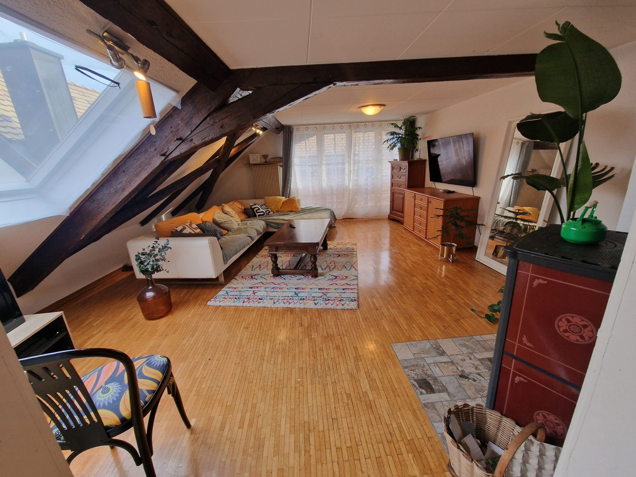 Salon ancien de la bâtisse PHOENIX, espace chaleureux avec poutres apparentes et murs en pierre avant travaux.